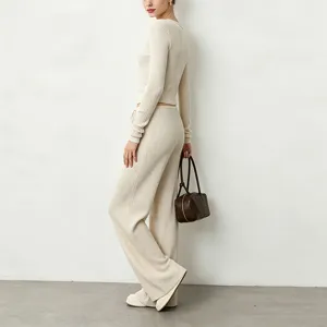 Detail view of beige ribbed knit long sleeve top and wide leg pants set, soft texture.