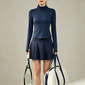 Ensemble haut de tennis à manches longues demi-zip et jupe de sport plissée taille haute.