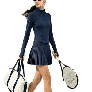Ensemble de sport pour femme haut manches longues zippé et jupe plissée taille haute.