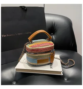 Bunter gestreifter Stroheimer-Taschendetail mit geflochtenem Design und Metallkette.