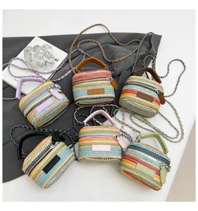 Detailansicht der bunten gestreiften Stroh-Mini-Eimer Tasche mit Kette und kurzem Griff.