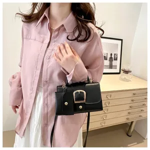 Chic black crossbody handbag for women with gold-tone buckle. Trendy retro daily accessory.