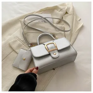 Silver metallic top handle shoulder bag with cross body strap and coin purse for women.