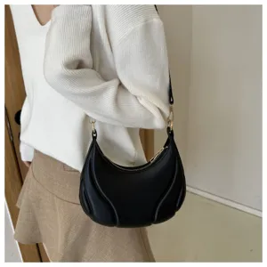 Detailansicht der schwarzen weichen Leder-Unterarmtasche mit einzigartigem geschwungenem Design.