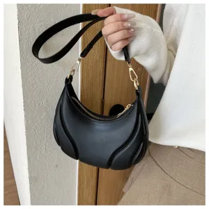 Schwarze Damen Umhängetasche aus weichem Leder, schicke Bogen-Achseltasche mit Metallteilen.