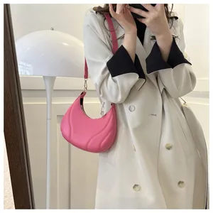 Detailansicht der stylischen pinken Halbmond-Umhängetasche aus weichem Leder mit Reißverschluss.