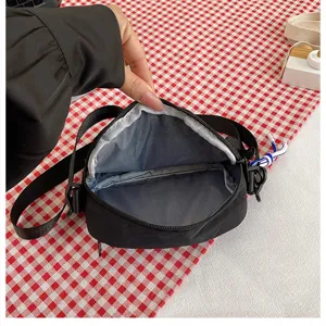 Vue détaillée du sac à bandoulière noir montrant la doublure intérieure et la fermeture.