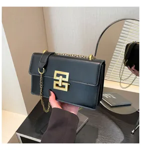 Detailansicht der eleganten schwarzen Leder-Umhängetasche mit Goldkette und Metallverschluss.