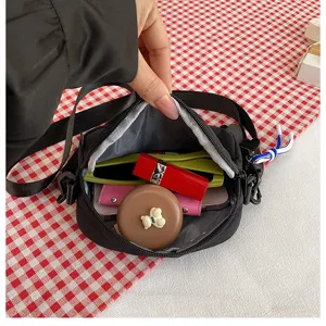 Vue détaillée de la capacité intérieure du sac bandoulière noir en nylon pour accessoires.