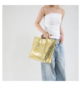 Detailansicht einer stilvollen goldenen Kroko-Tasche, die Struktur und Design zeigt.