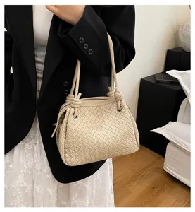 Chic beige woven shoulder bag with metal cord knots, elegant large capacity tote for women.