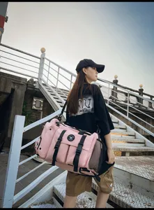 Vista de cerca detallada de la bolsa de fitness de viaje multifuncional rosa en escaleras metálicas.