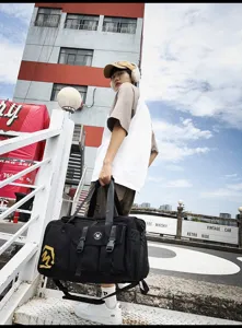Gran bolsa de viaje negra con compartimentos multifuncionales y correa ajustable.