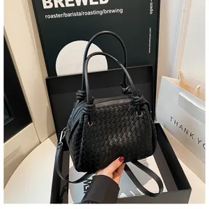 Black woven leather handbag with knot handles, stylish shoulder tote bag for women.