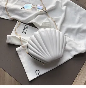 Borsa a tracolla a conchiglia in vernice bianca con catena dorata, stile chic.