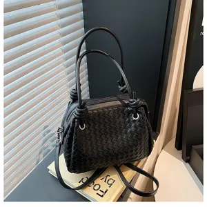 Black woven leather tote bag featuring metal knot details and spacious daily shoulder design.