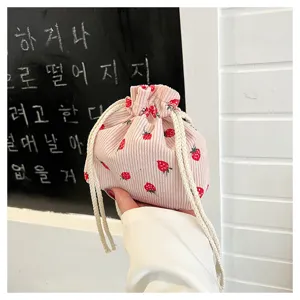 Detailed view of cute strawberry print corduroy drawstring pouch, mini casual cosmetic handbag.