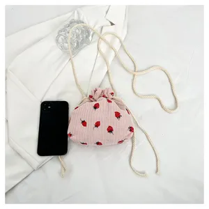 Pink corduroy strawberry print drawstring crossbody bag detail showcasing cute aesthetic style.