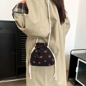 Chic corduroy strawberry bucket bag with drawstring, stylish cross-body bag for women.