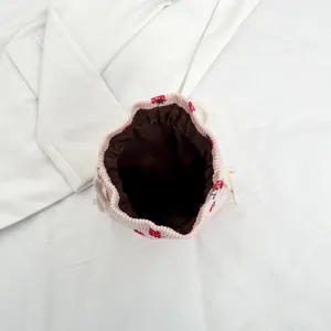 Pink corduroy strawberry print drawstring bucket bag top view main product image display.