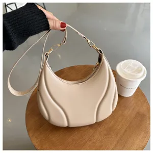 Beigefarbene Schultertasche aus weichem Leder mit einzigartigem Plissee-Design und Goldteilen.