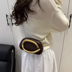 Mini sac bandoulière en cuir marron foncé avec poignée dorée en forme de C et chaîne.