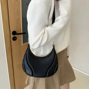 Schwarze weiche Leder Achseltasche für Damen, modische geschwungene Handtasche im Herbst.