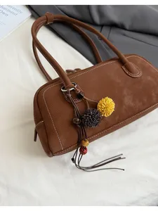 Brown retro baguette shoulder bag with chic tassel charm, stylish women vintage handbag detail