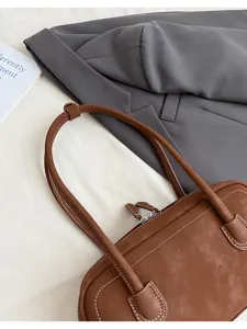 Brown retro shoulder baguette bag detail view, chic minimalist faux leather everyday purse for women.