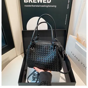 Black woven leather tote bag with double handles and shoulder strap for women daily use.