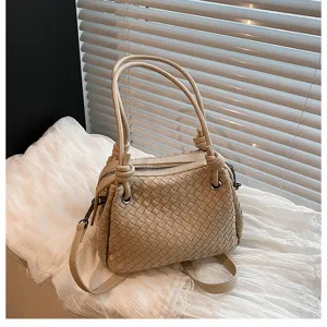 Detailed view of the beige woven leather shoulder bag with metal knot handles and zipper.