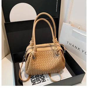 Beige woven leather handbag with double knotted handles and elegant metallic ring details.