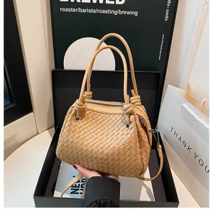 Exquisite beige woven leather handbag detail, featuring unique knotted handles and chic design.