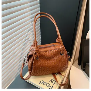 Brown woven leather handbag with knotted handles, stylish large shoulder tote bag for women.