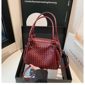 Detailed close-up of woven leather handbag showcasing intricate weaving and stylish knot handles.