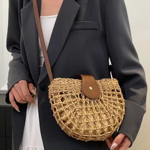 Woven straw crossbody bag for women, chic summer beach saddle bag with brown leather flap.
