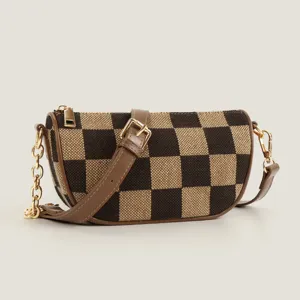 Brown tan checkerboard canvas crossbody bag close-up detail gold chain strap chic.