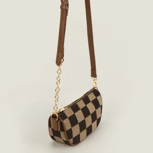 Detailed view of trendy checkerboard canvas crossbody bag with stylish gold chain strap.