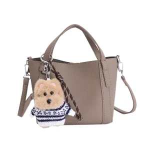 Vintage litchi grain PU bucket bag with cute plush dog keychain, elegant crossbody bag.