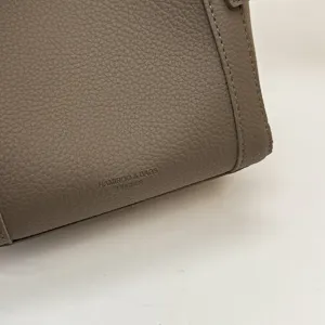 Detailed view of grey litchi pattern PU leather bucket handbag showing fine texture.