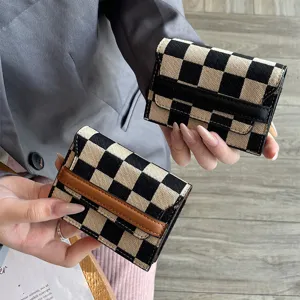 Detail shot of stylish checkerboard card holder with leather trim, showing compact card slots.