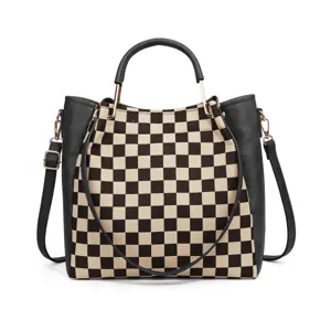 Stylish black and white checkerboard handbag with leather trim and shoulder strap.