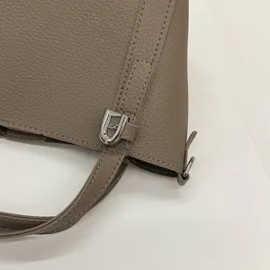 Taupe pebbled PU leather handbag detail, elegant crossbody bucket bag with silver hardware.
