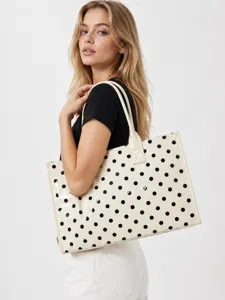 Detailed view of cream and black polka dot tote bag, glossy finish, double straps, casual style.
