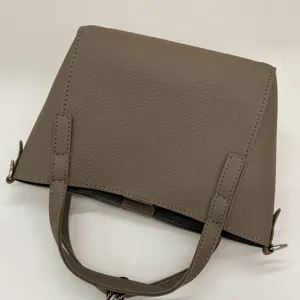 Detailed shot of taupe textured PU leather handbag featuring fine stitching and sturdy handles.