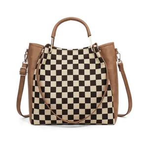 Black and white checkerboard canvas handbag with brown leather trim and crossbody strap.