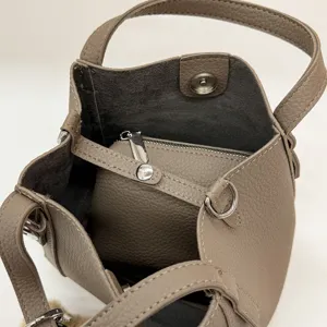 Detailed view of the taupe litchi pattern PU bucket handbag, showing interior pouch and hardware.