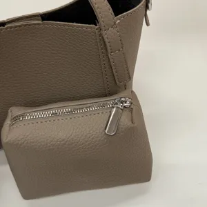 Detailed view of the pebble texture PU leather tote bag and matching zipper pouch, stylish.