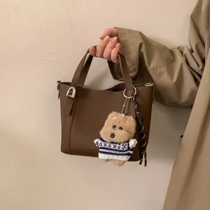 Vintage pebbled PU leather bucket bag with cute bear charm, stylish top handle handbag.