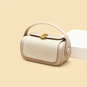 Beige fashion handbag with woven front panel, top handle and golden clasp for women.